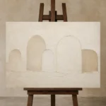 Soft Ivory Arches Minimalist Wall Art Canvas Print displayed on a studio easel