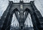 Graphite brooklyn bridge wall art print featuring granite archways, steel cables, architectural details, and dramatic urban perspective for elegant interiors