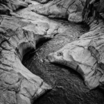 Silver and cobalt black and white photography wall art print featuring an aerial mountain river with granite formations and flowing water patterns for elegant interiors